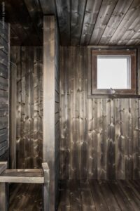 Sauna tummalla kuultomaalilla – takaseinä pystypaneelia, sivuseinä vaakapaneelia.